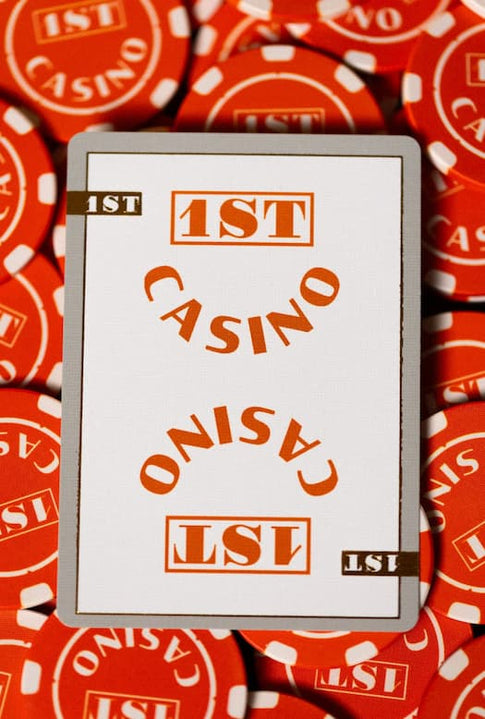 Card with '1ST CASINO' text on a background of red and white casino chips.