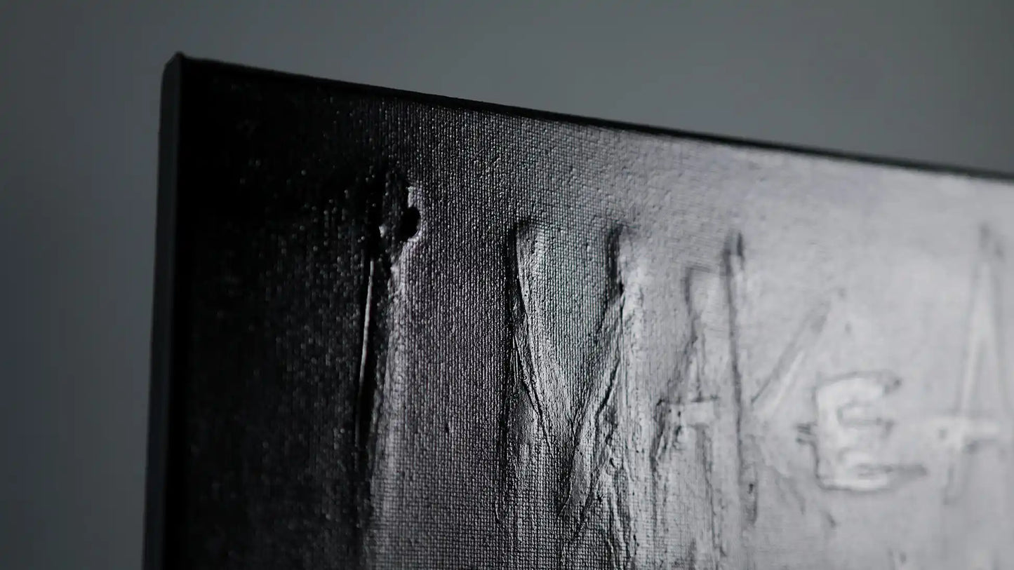 Detail of SURVIVAL painting by Daniel Madison showing raised texture where original message remains visible beneath black paint, representing honesty hidden behind insecurity